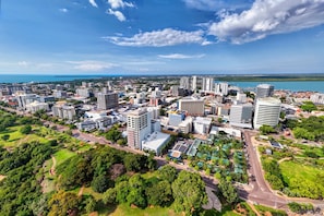 A cityscape with modern buildings, roads, and green spaces. - CBD Darwin Studio With Rooftop Deck (Darwin)