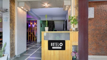 A hotel reception desk with a sign indicating it is company-serviced.