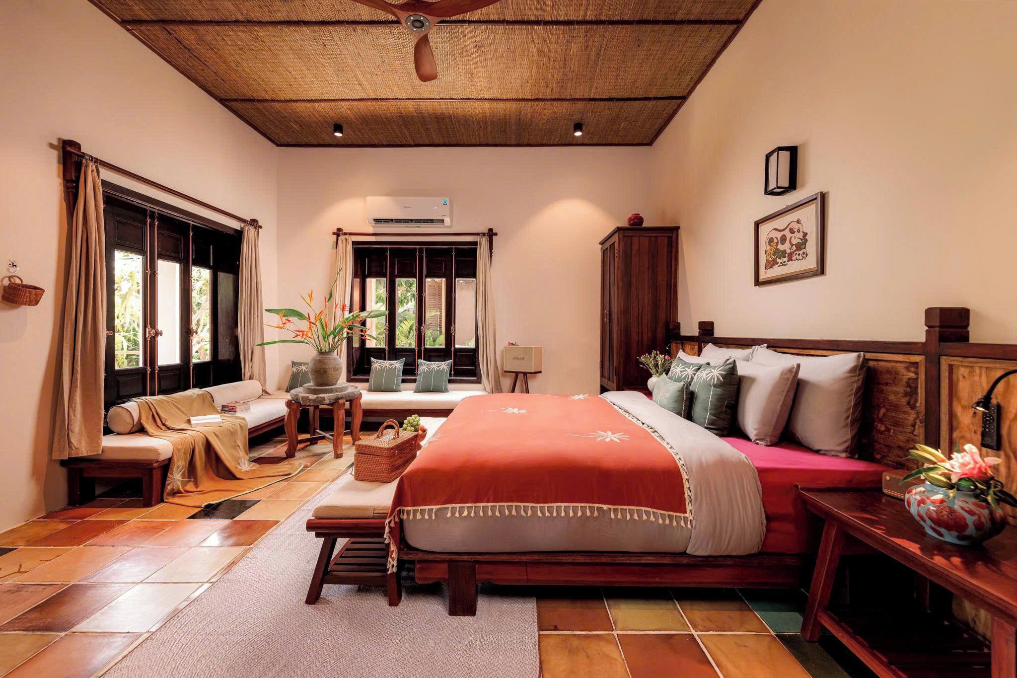 A spacious bedroom with a large bed, a sofa, and a dining table.