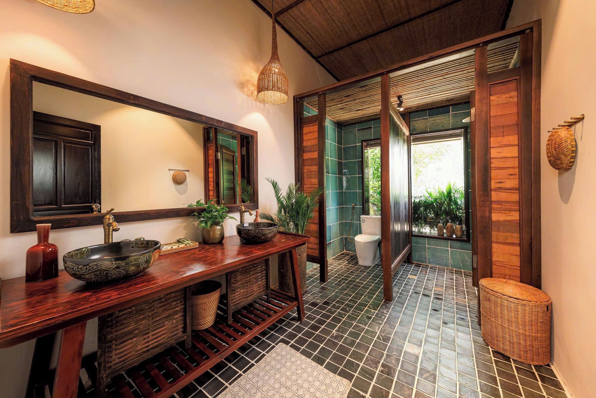 Un bagno con un mobile vanitario in legno, uno specchio grande e un lampadario a sospensione.