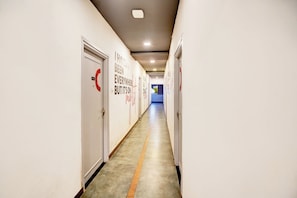 Un pasillo con puertas a ambos lados, cada una identificada con un círculo rojo y un número.
