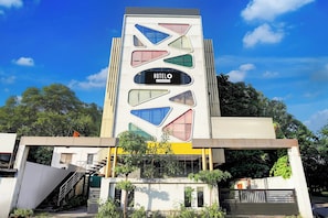Un moderno edificio de hotel con una fachada geométrica distintiva y un letrero que indica que ofrece servicios para empresas.