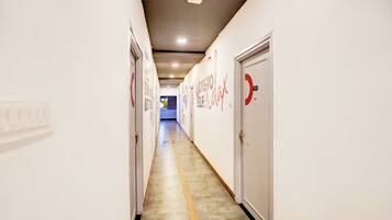 A hallway with doors on both sides, each marked with a red logo and the text 'Relax.'