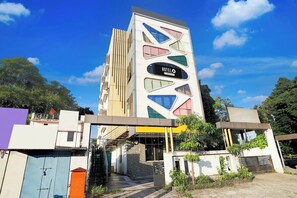 Un moderno edificio de hotel con una fachada geométrica distintiva y un letrero que indica que es un hotel de servicios corporativos.