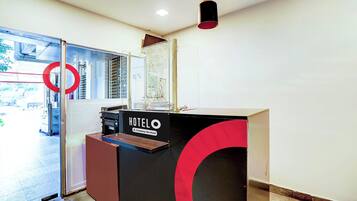 Balcão de recepção de hotel com placa indicando serviço corporativo.