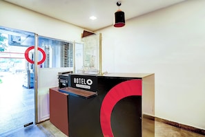 Un mostrador de recepción de hotel con un cartel que indica que es atendido por la empresa.