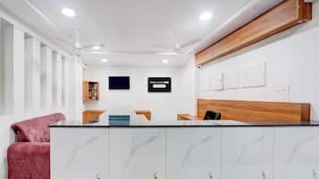 A reception area with a marble counter, wooden paneling, and a sign indicating a company service.