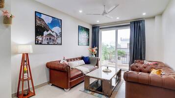A modern living room with a brown leather sofa, a coffee table, and a ceiling fan.