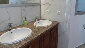 A bathroom with two sinks, a mirror, and a window. - Villa Faro Studio 2 (Pajara)