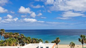 A beach view with palm trees, a clear sky, and a calm sea. - Villa Faro Studio 2 (Pajara)