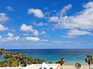 A beach view with palm trees, a clear sky, and a calm sea. - Villa Faro Studio 2 (Pajara)