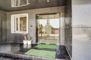 Un espace d’accueil doté d’un comptoir en marbre, d’une fenêtre et d’une porte avec des panneaux de verre.