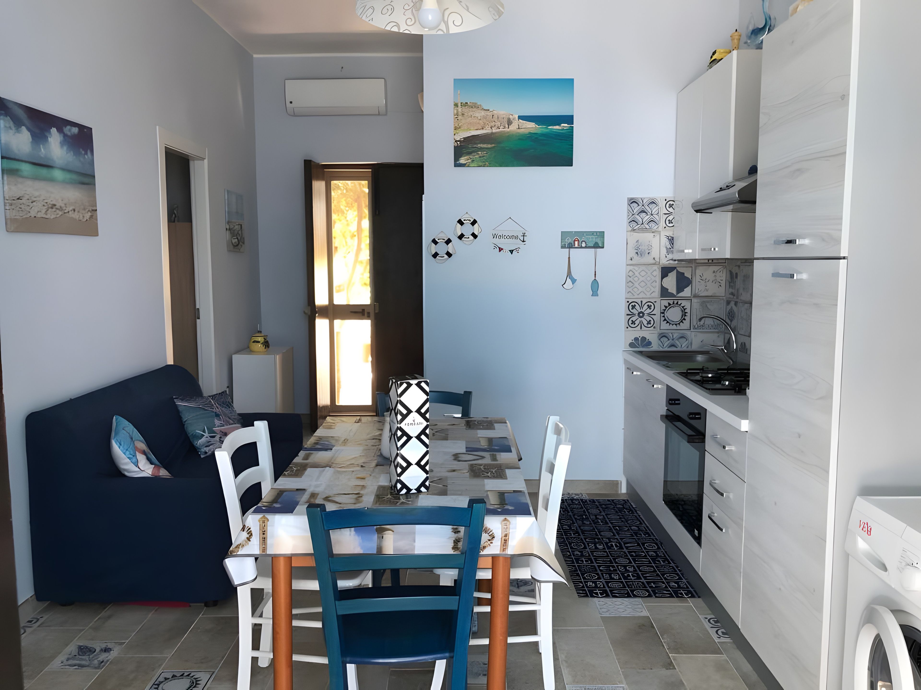 Un espacio habitable compacto con comedor, kitchenette y vistas al exterior.