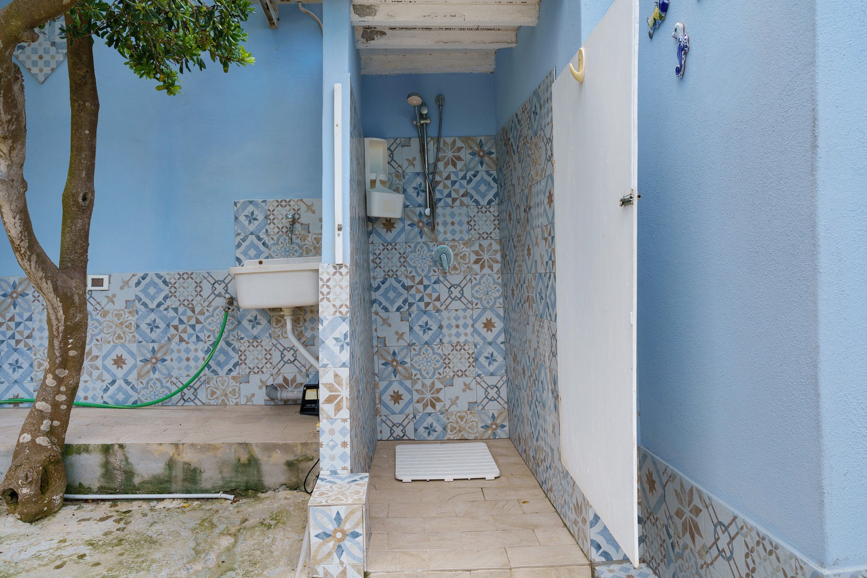 Een compacte badkamer met toilet, douche en betegelde wanden.