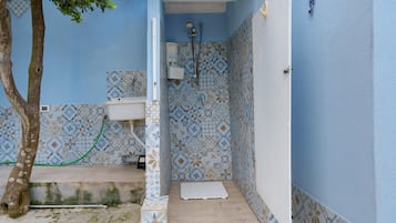 Een compacte badkamer met toilet, douche en betegelde wanden.