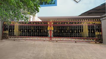 A gated entrance with decorative metalwork and a clear pathway leading to a building.