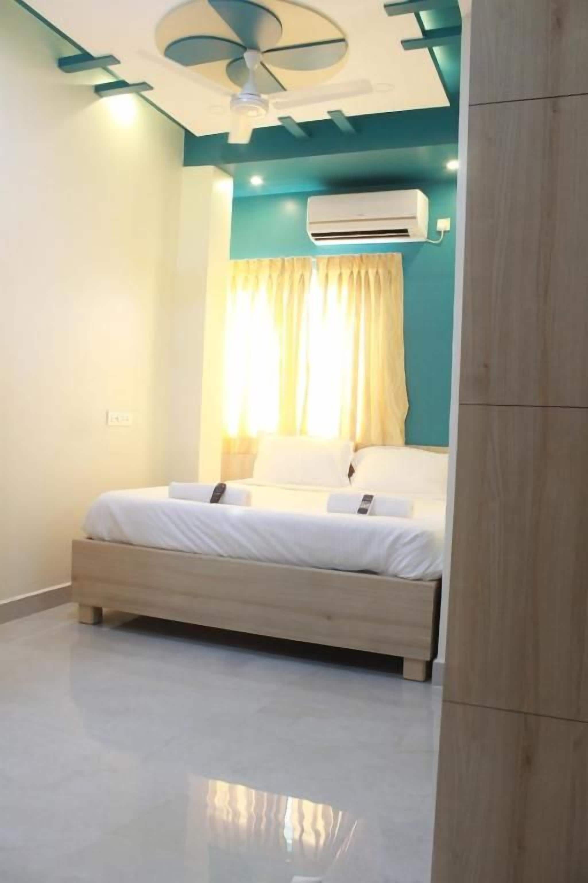 Un dormitorio con cama, equipo de aire acondicionado y ventilador de techo.