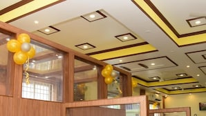 A restaurant interior with booths, wooden paneling, and a ceiling with recessed lighting. - JFIVE RESIDENCY (Chennai)