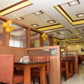 A restaurant interior with booths, wooden paneling, and a ceiling with recessed lighting. - JFIVE RESIDENCY (Chennai)