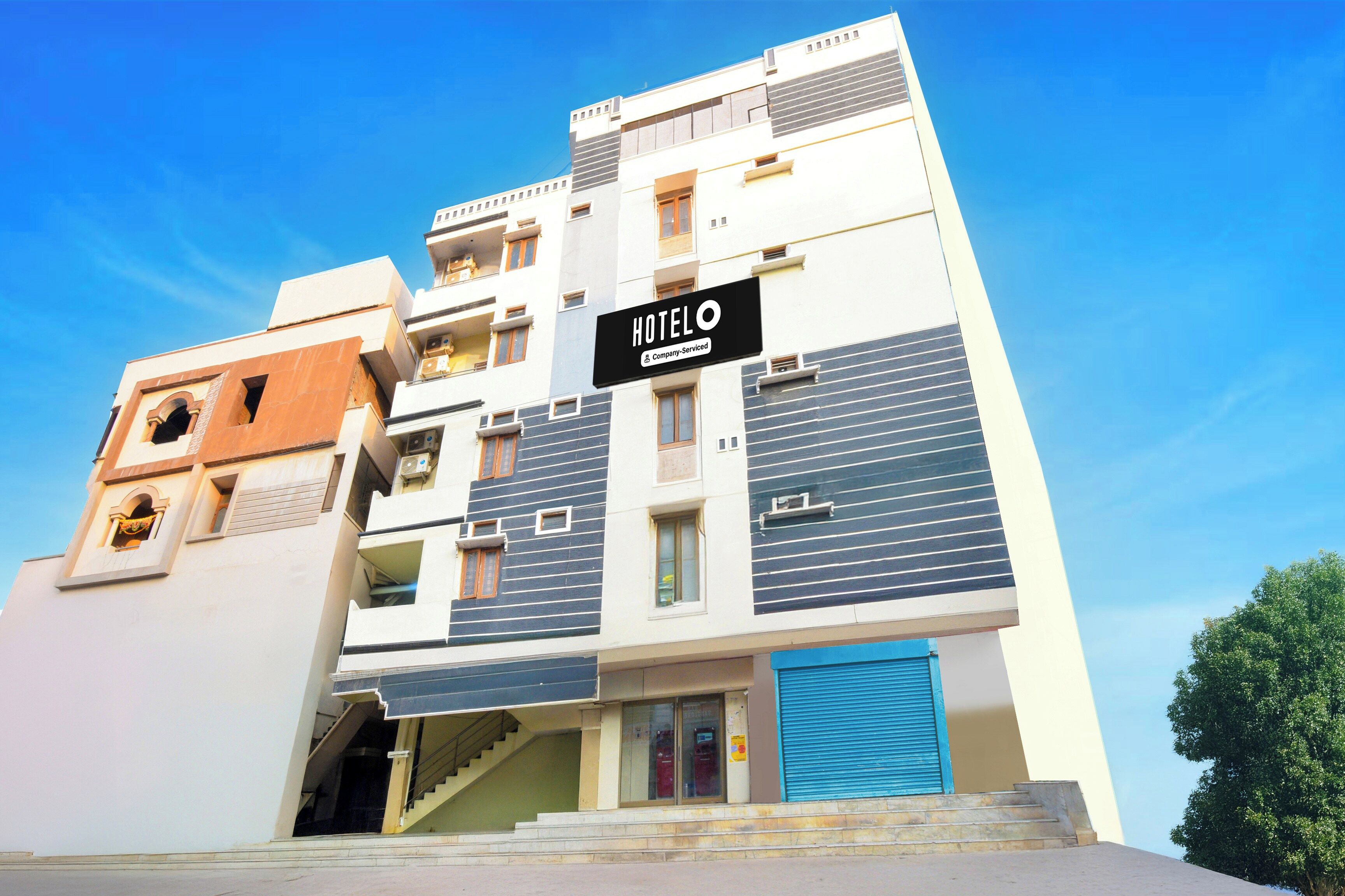 A multi-story hotel with a sign indicating it is company-serviced.