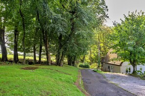 Uma estrada rural que leva a uma pequena casa com entrada de cascalho.