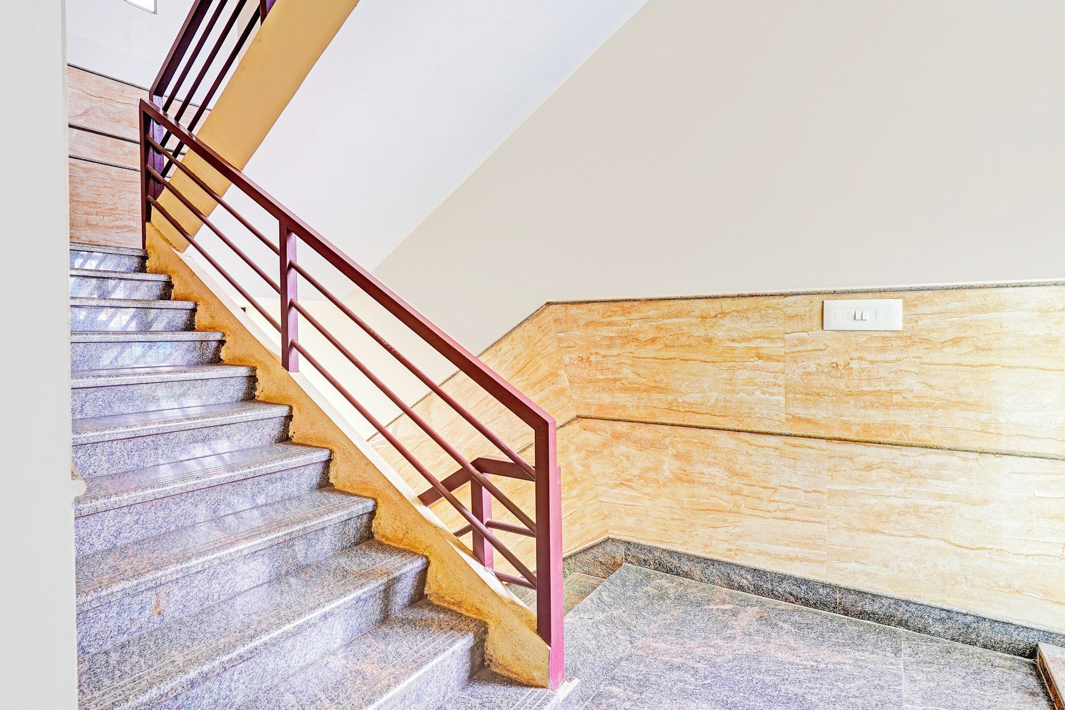 Un escalier avec une rampe métallique et des marches en pierre.