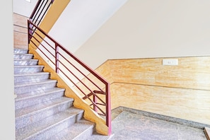 A staircase with a metal handrail and stone steps. - Hotel O Srigandhakavalu Formerly (Bengaluru)