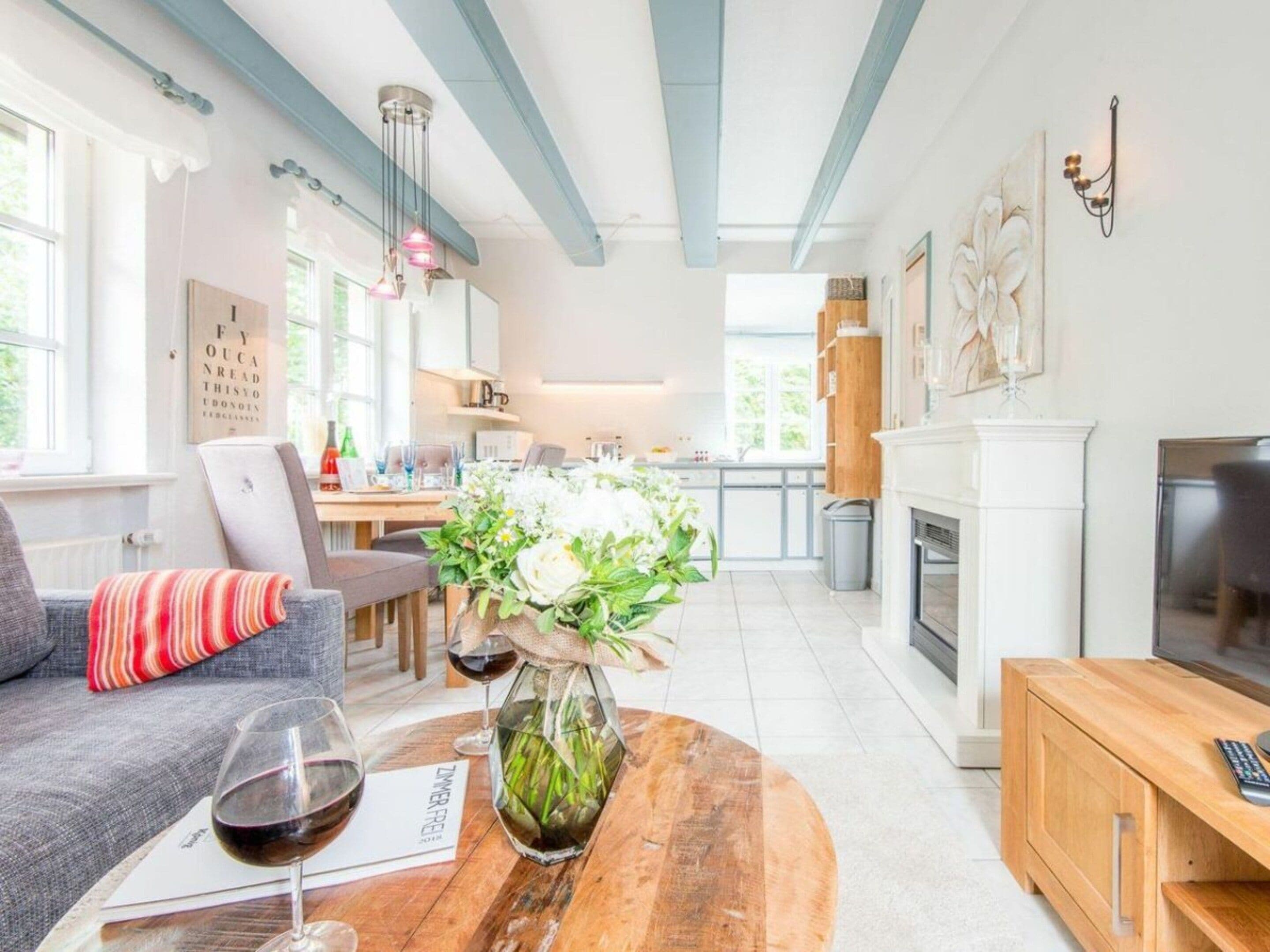 Un salon moderne avec un canapé, une table basse ornée d’un vase et une cheminée.