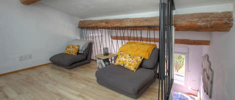 A room with two grey sofas, a small wooden table, and a window with a view.