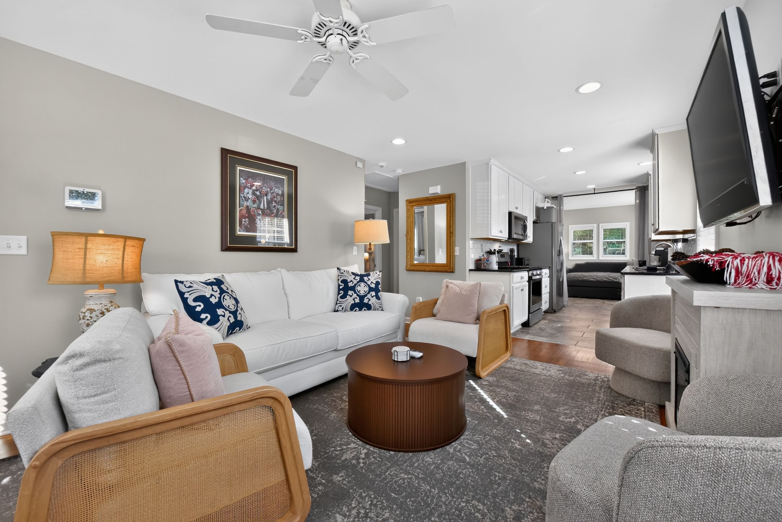 A modern living room with a white sofa, a coffee table, and a ceiling fan.