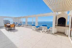 A rooftop terrace with a dining set, lounge chairs, and a fireplace. - Cabana Beach by First Private Stays (uMhlanga)
