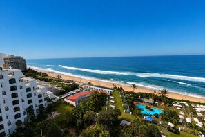 A resort with a pool, beach, and ocean view.