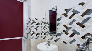 Ein Badezimmer mit einem weißen Waschbecken, einem Spiegel und einer Wand mit Muster.