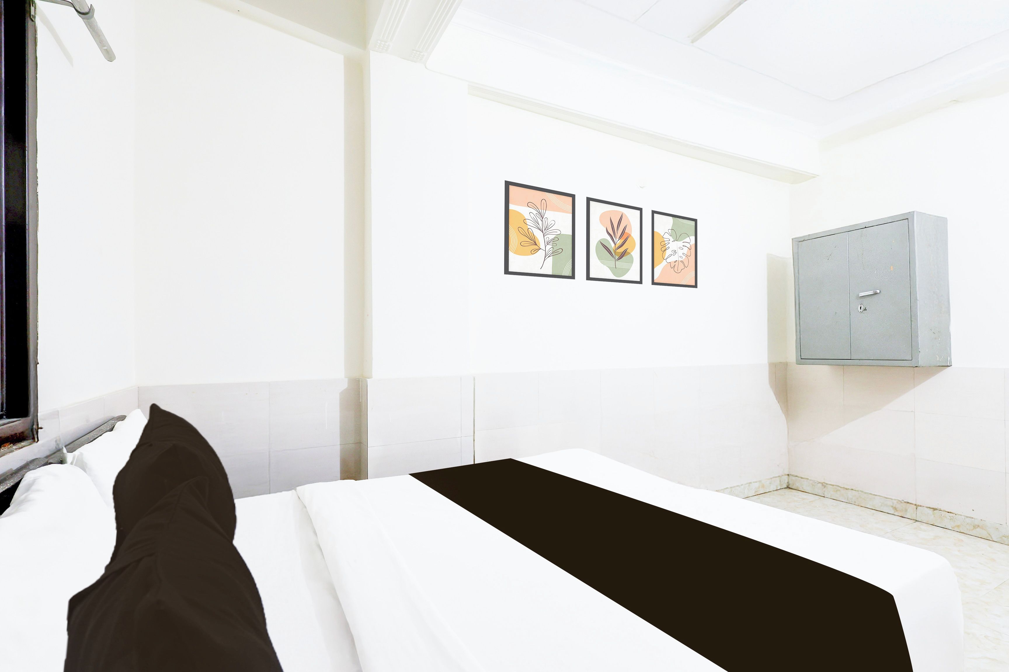 Una habitación de hotel con una cama, un ventanal y un mueble de pared.