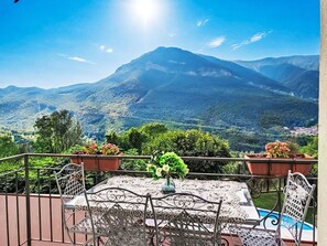 Eine Terrasse mit Tisch und Stühlen mit Blick auf eine Berglandschaft.