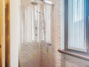 Eine Duschkabine mit Handdusche und Deckenbrause.