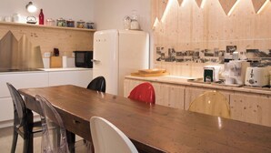 A modern kitchen with a wooden countertop, a refrigerator, and a dining area with chairs. - Lovely apartment for 6 people with WIFI and TV (Bormio)