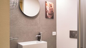 A modern bathroom with a white sink, a round mirror, and a toilet paper holder. - Lovely apartment for 6 people with WIFI and TV (Bormio)