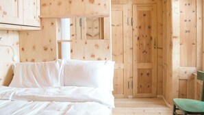 A wooden cabin interior with a bed, a chair, and a door. - Lovely apartment for 6 people with WIFI and TV (Bormio)