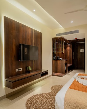 Une chambre moderne dotée d’un téléviseur à écran plat, d’étagères intégrées, d’une table de chevet et d’un tapis à motifs.