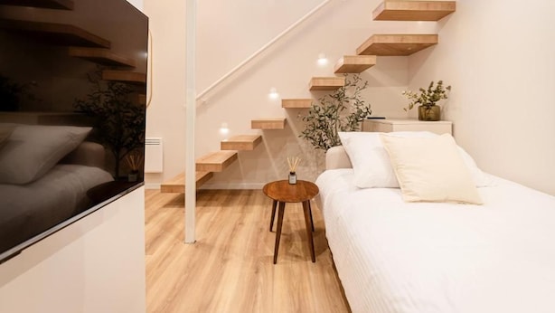 A modern interior with a staircase, a sofa, and a small round table. - Szerb Boutique Suites by BQA (Budapest)