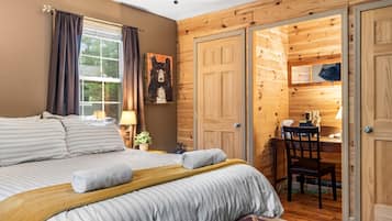A bedroom with a bed, a desk, and a chair.