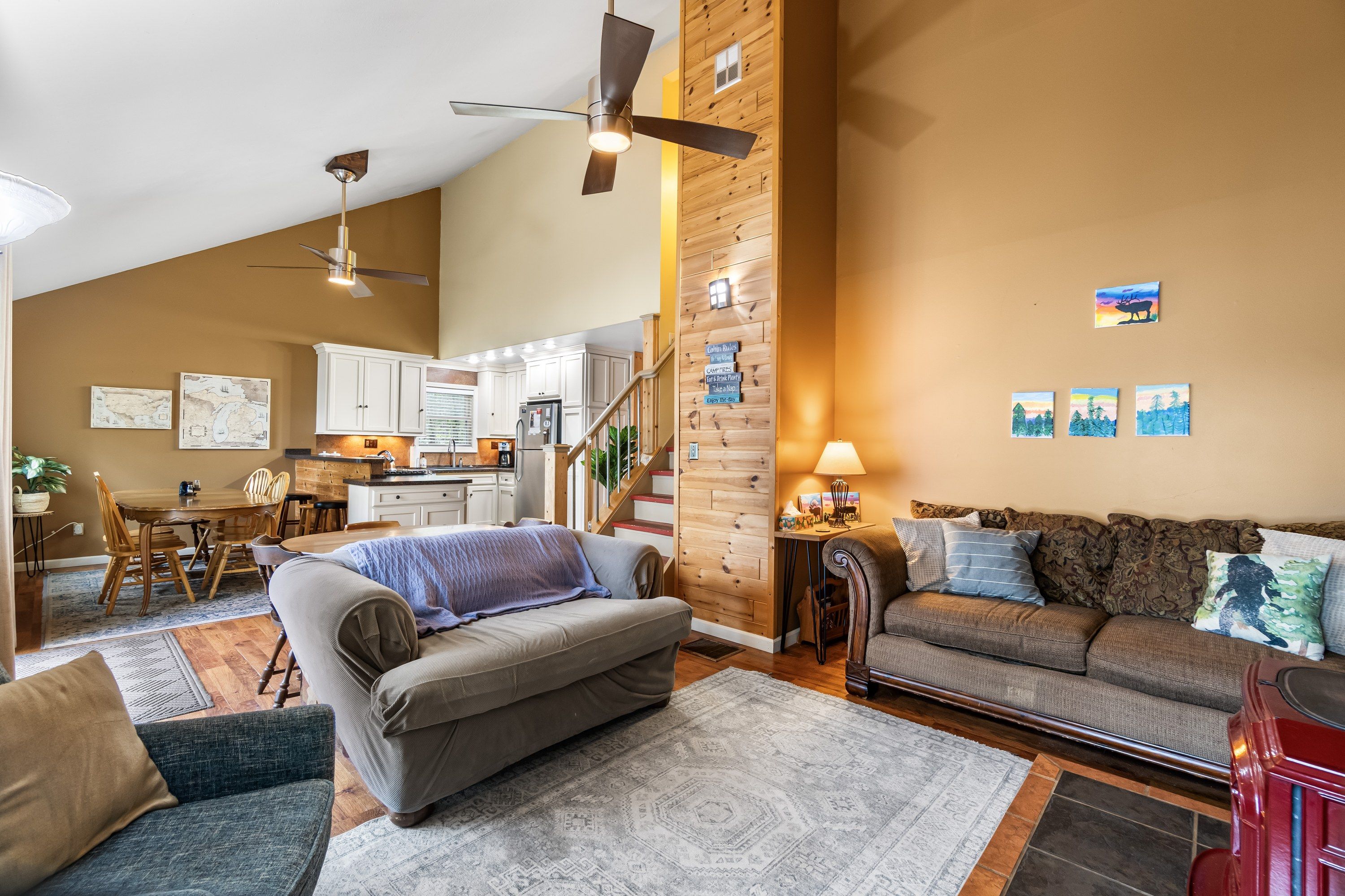 A spacious living area with a sofa, a dining table, and a kitchen in the background.