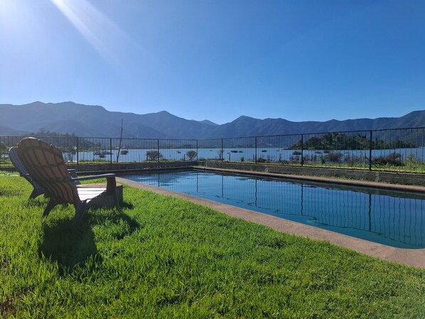 A swimming pool with a view of mountains and a chair.