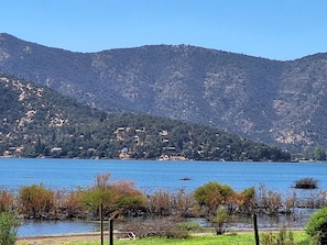 A lake with mountains in the background and a small island with vegetation in the foreground.