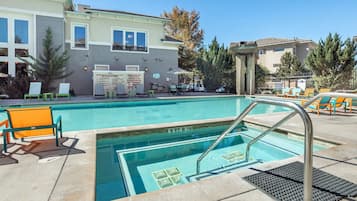 A swimming pool with a 3 ft 6 in depth, surrounded by lounge chairs and a building with a signboard.