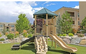 A playground with a slide and climbing structure, surrounded by landscaped areas and residential buildings. - South Reno 1BR Near Reno Events Pool Hot Tub Gym (Reno)