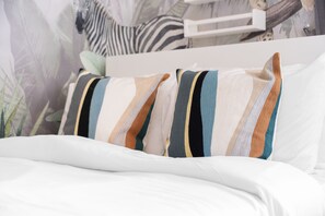 A bed with white bedding and striped pillows. - Stayshort - Stylish 4-bedroom Oasis in Peaceful Creek Harbour (Dubai)