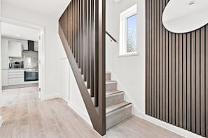 Un escalier avec des rampes en bois menant à une cuisine.