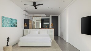 Ein modernes Schlafzimmer mit einem großen Bett, einem Deckenventilator und einem großen Spiegel.